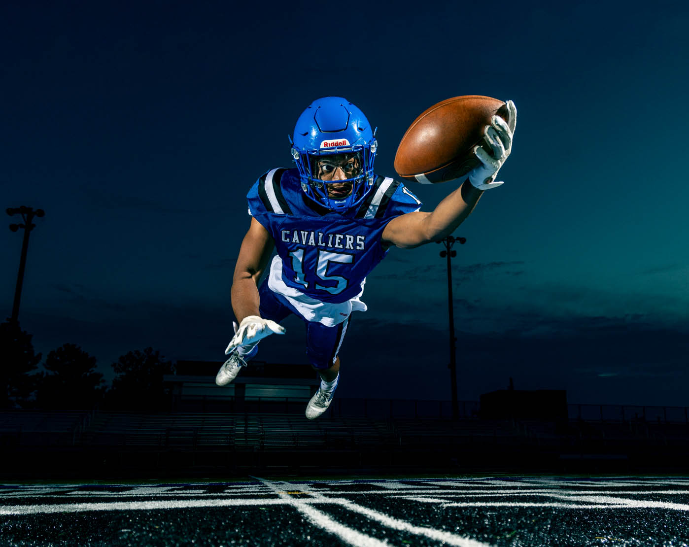 A high school football player dives to make a one-handed catch during a Delaware Senior Portrait shoot.